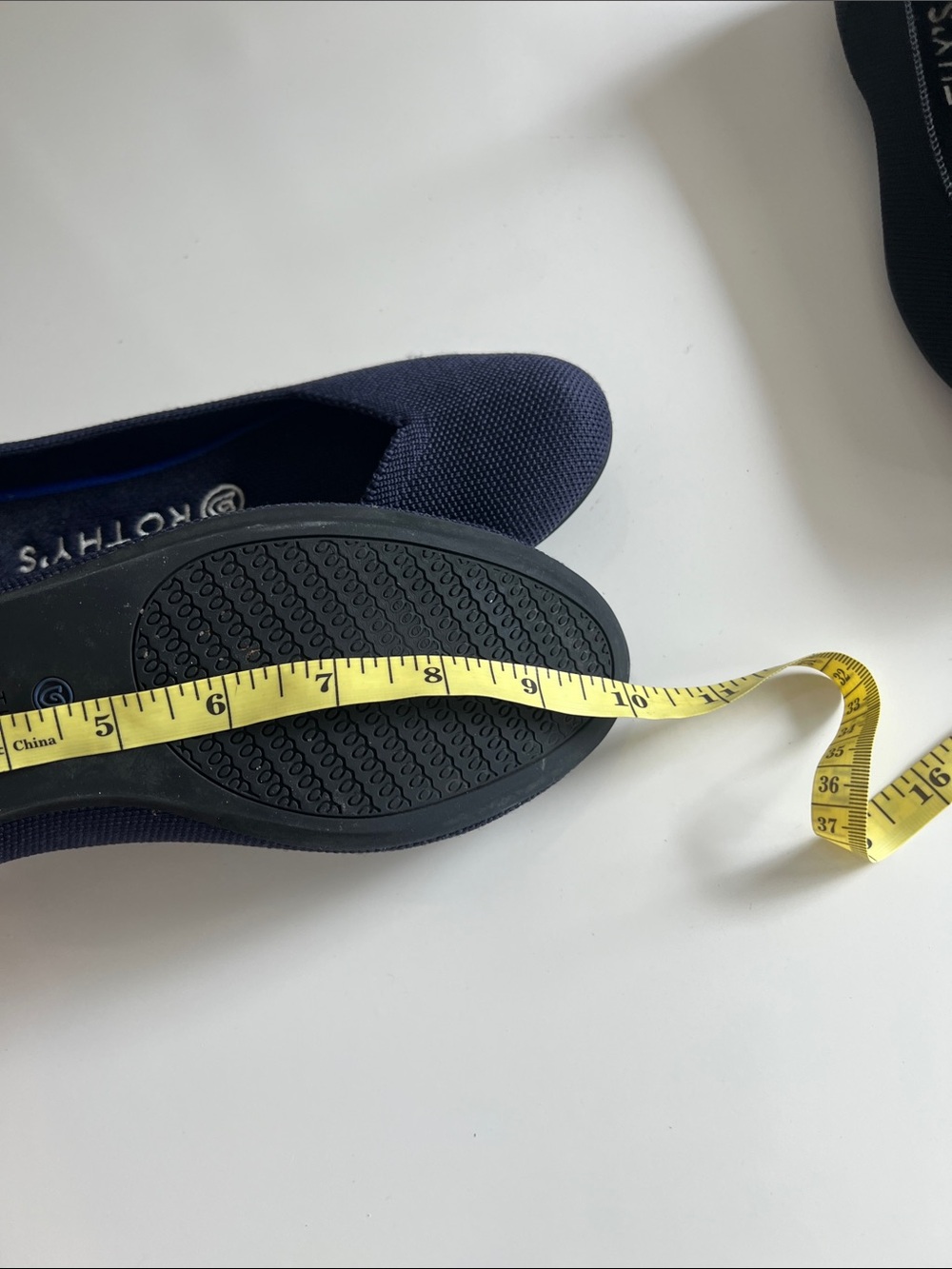 Rothy's navy blue round-toe knit flat shoes featuring a distinctive bright blue - Picture 12 of 12